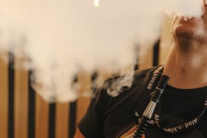 guy exhaling hookah smoke in a big plume