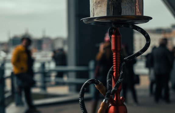 View of a hookah pipe with people in the distance.