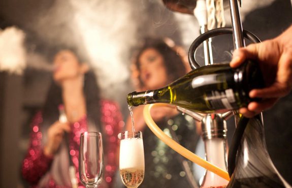 Pouring wine in a smoky room of hookah smokers.